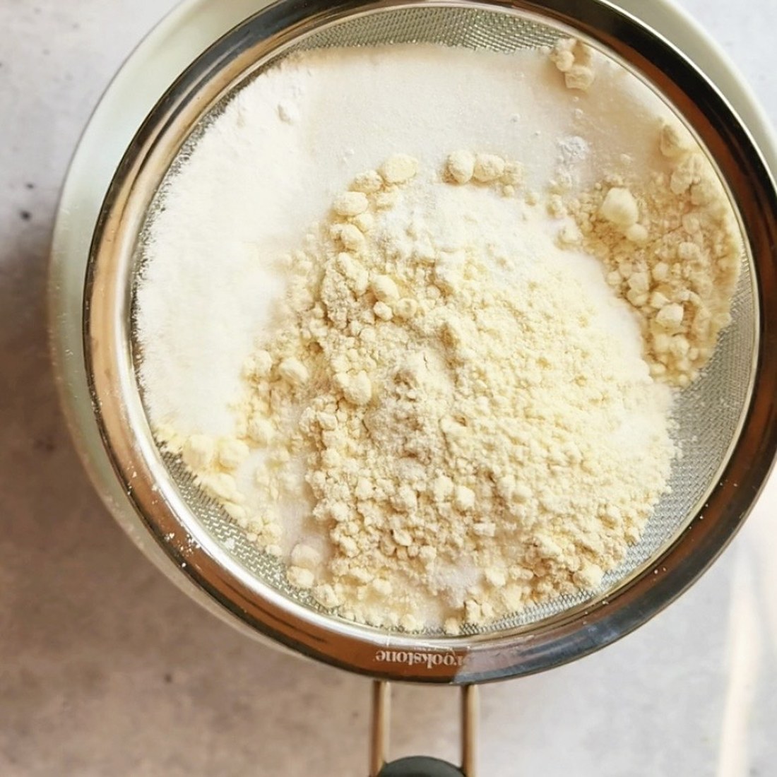 Sifting flour, sugar, baking powder and salt together for blueberry muffins