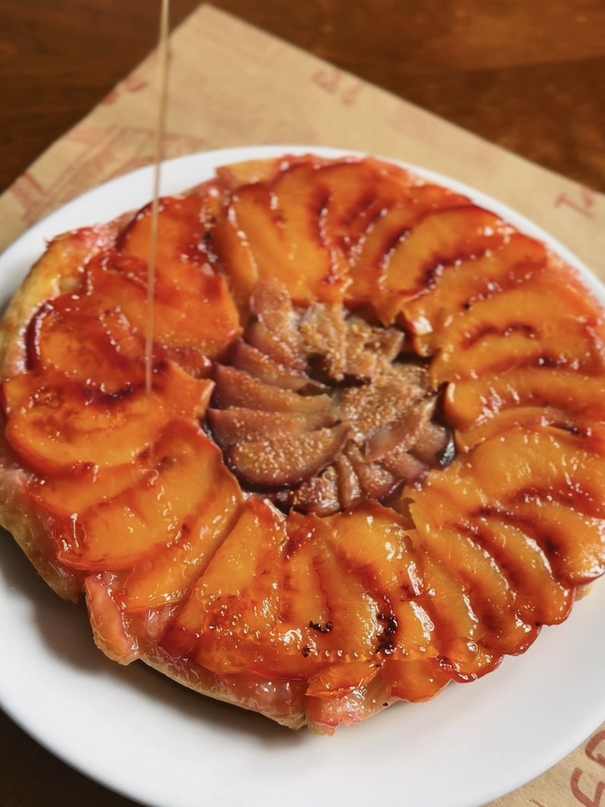 Drizzling honey over the warm upside down fig and peach tart