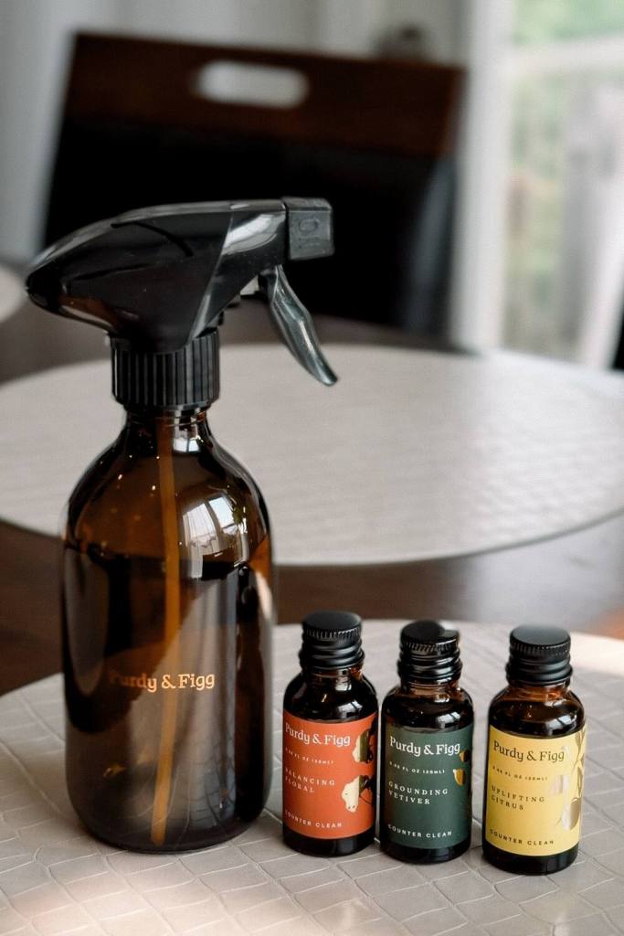 Purdy and Figg amber glass spray bottle with balancing floral, grounding vetiver and uplifting citrus counter clean concentrates