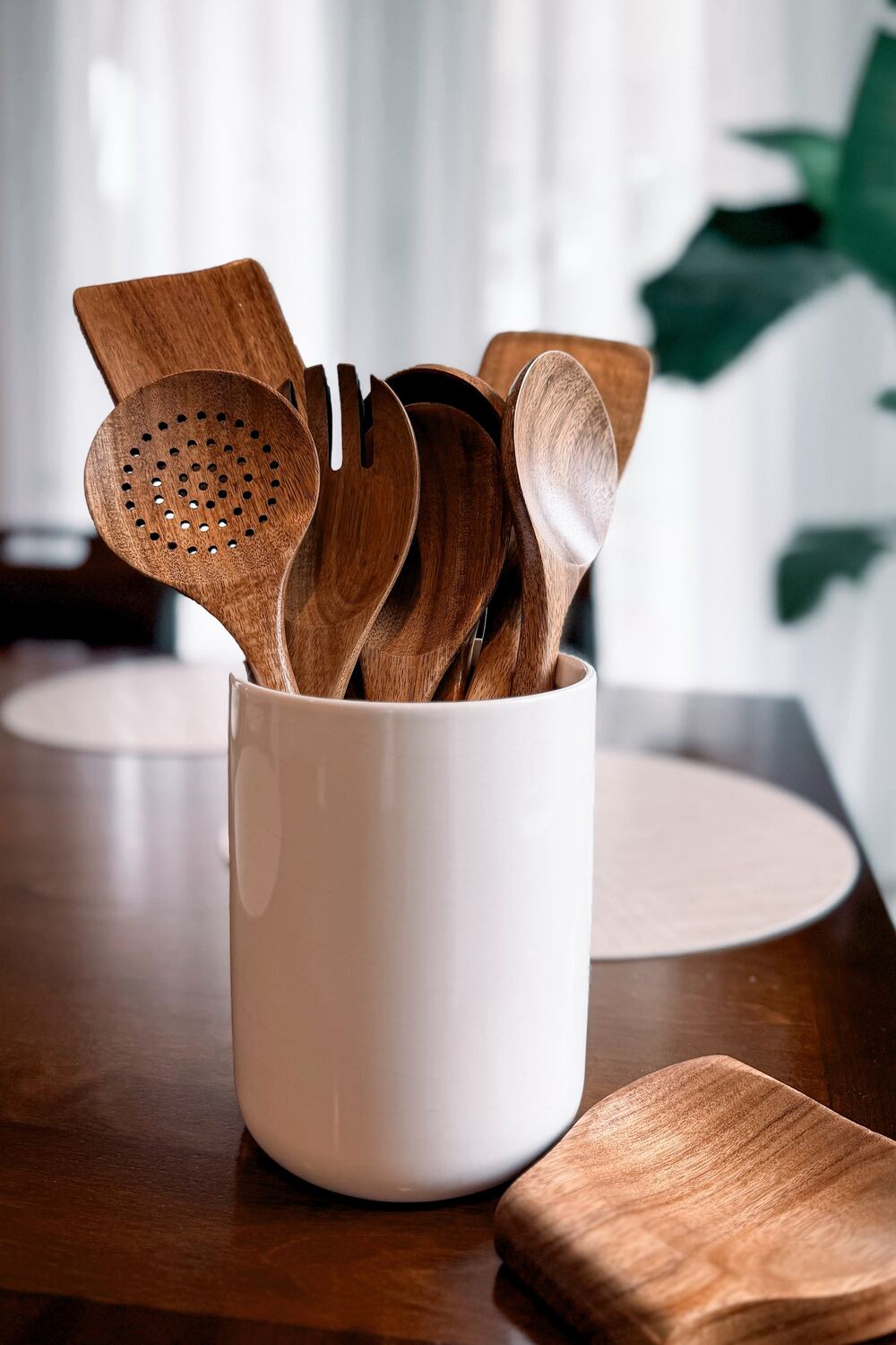 Acacia wooden spoon set in a white ceramic utensil crock