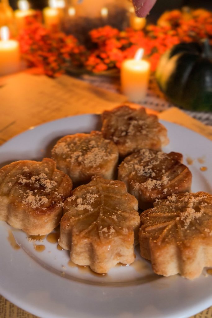 Plate of maple dipped fall shortbread dusted with brown sugar on a candlelit table