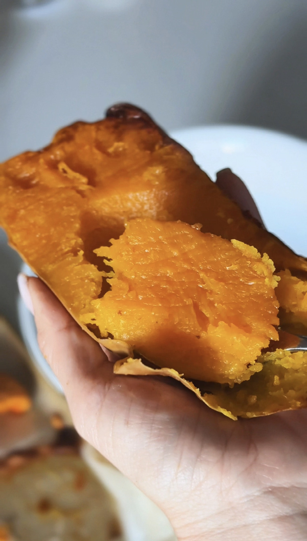 Scooping the roasted flesh out of the butternut squash skin with a spoon