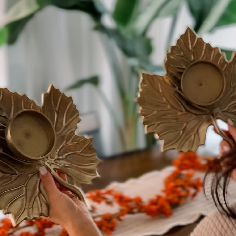 Two brass leaf shaped candle holders