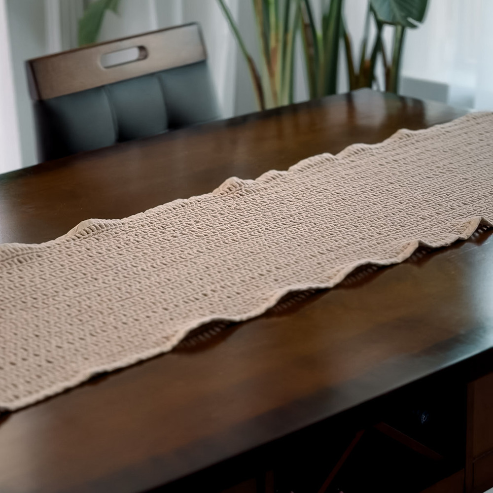 Cream macrame table runner laid down the middle of a dining table