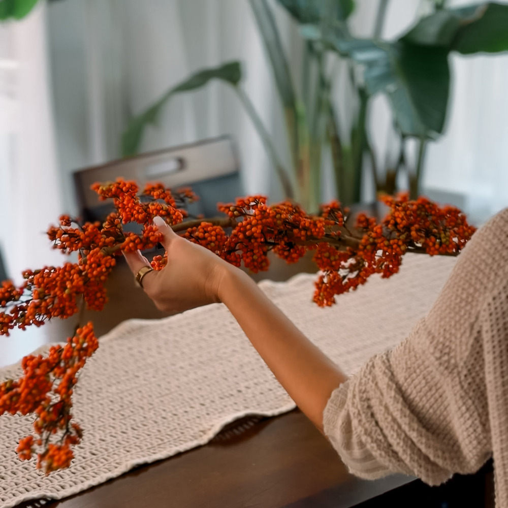 Orange bittersweet berry garland laid along a table runner