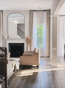 Living room with the arched mirror, curtains and floor vase