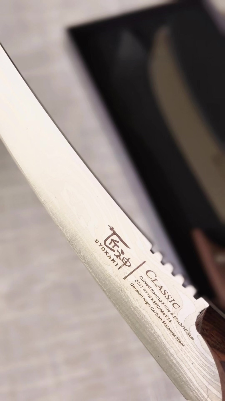 Close up of the long curved SYOKAMI breaking knife blade showing the pattern in the steel